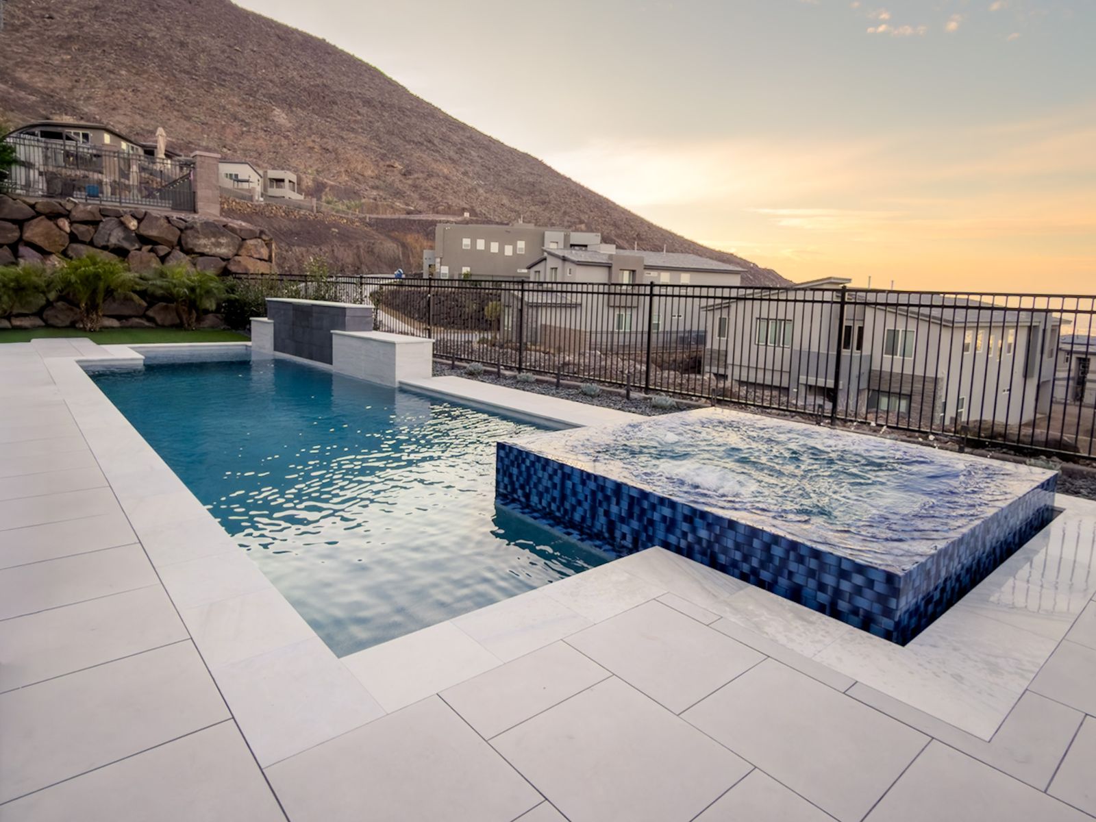 Vanishing-edge custom pool with fire table at dusk — Pools R Us Arizona